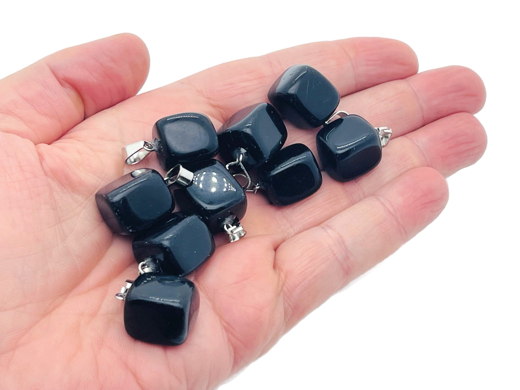 Obsidian tumbled gemstone pendant with polished surface, hanging on a silver chain, showcasing natural black gemstone with subtle luster.