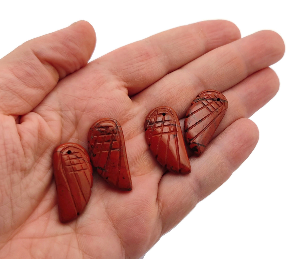 Red Jasper angel wing crystal pendant with hole charm, featuring detailed gemstone carving and polished finish.