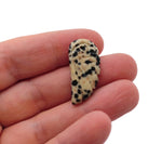 Dalmatian Jasper angel wing crystal pendant with hole charm, featuring black and beige spotted stone and silver-tone metal accents.
