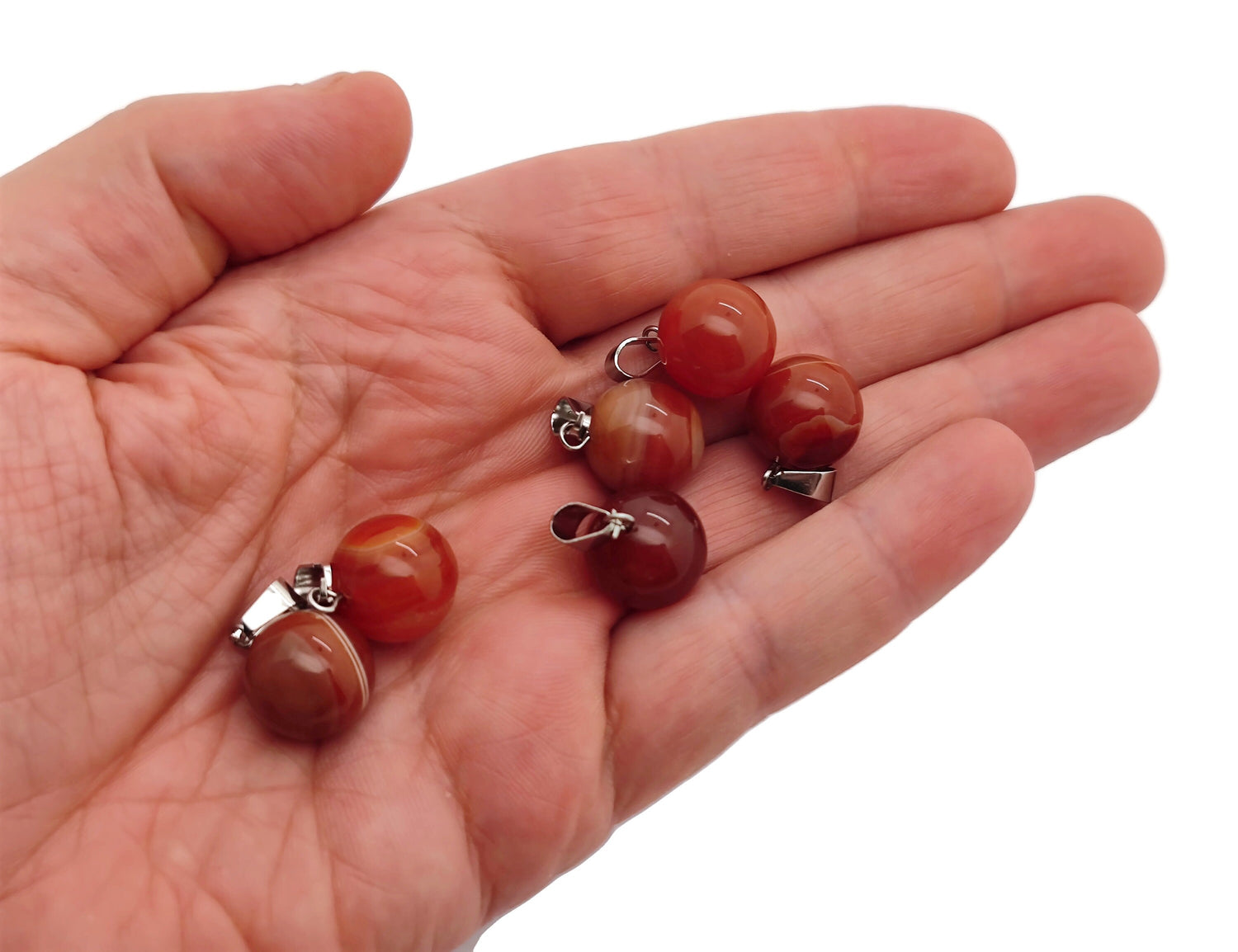 Carnelian crystal ball pendant with polished round gemstone for jewelry making, showcasing vibrant orange-red color and smooth surface.