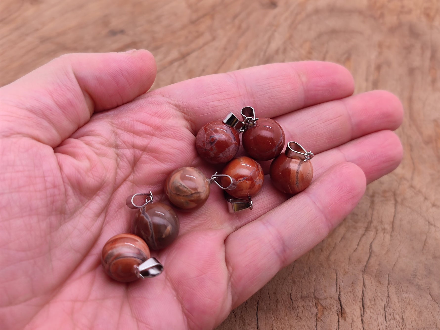 Red Jasper crystal ball pendant from GemstoneGO, showing a polished round gemstone used for jewelry making.
