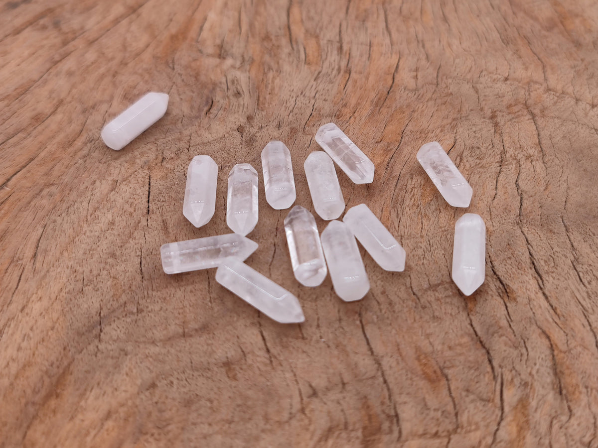 Clear quartz point crystal pendant with drilled hole, showcasing a natural, polished quartz gemstone by GemstoneGO.