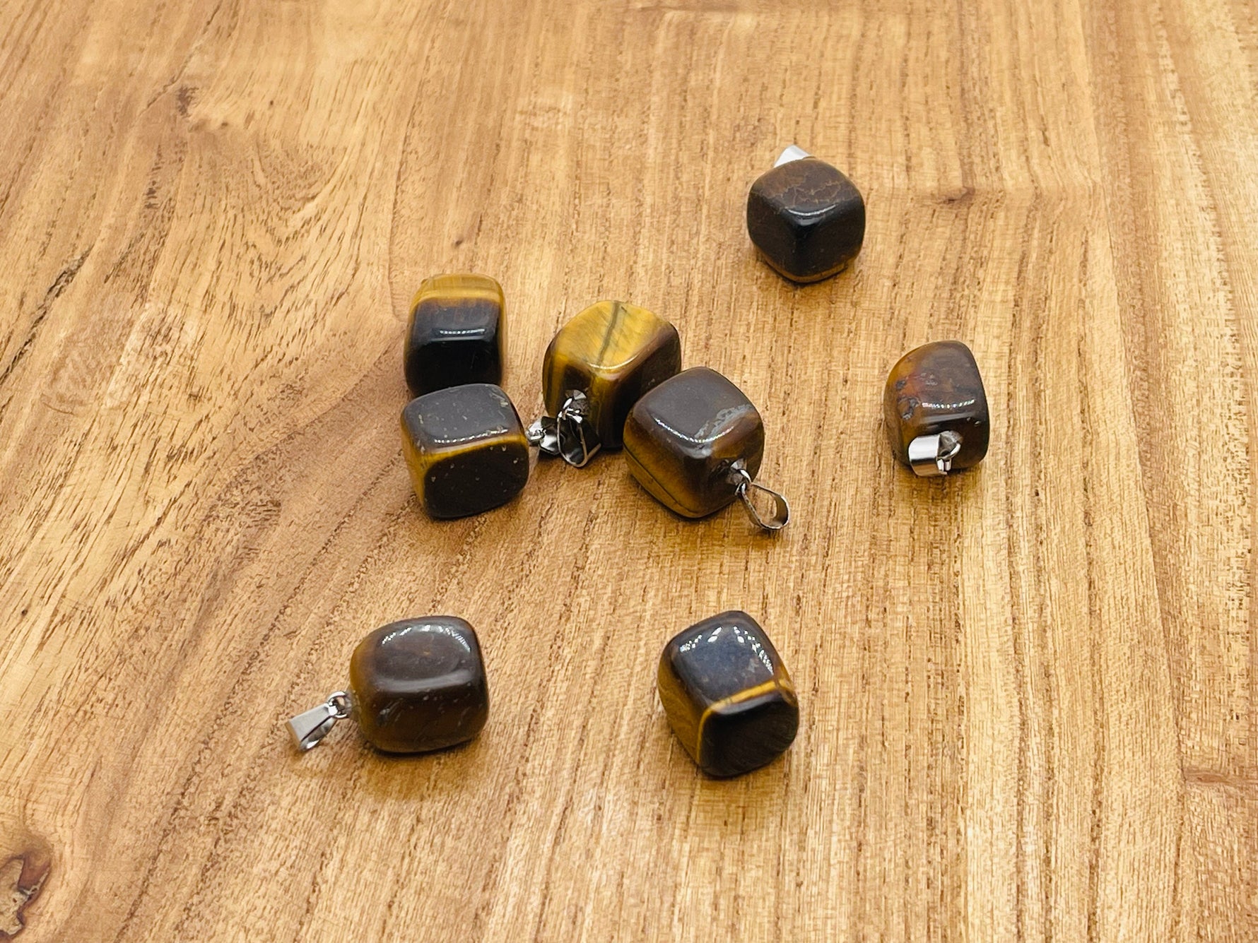 Tiger Eye tumbled gemstone pendant from GemstoneGO featuring a smooth, polished brown and gold stone on a simple chain.