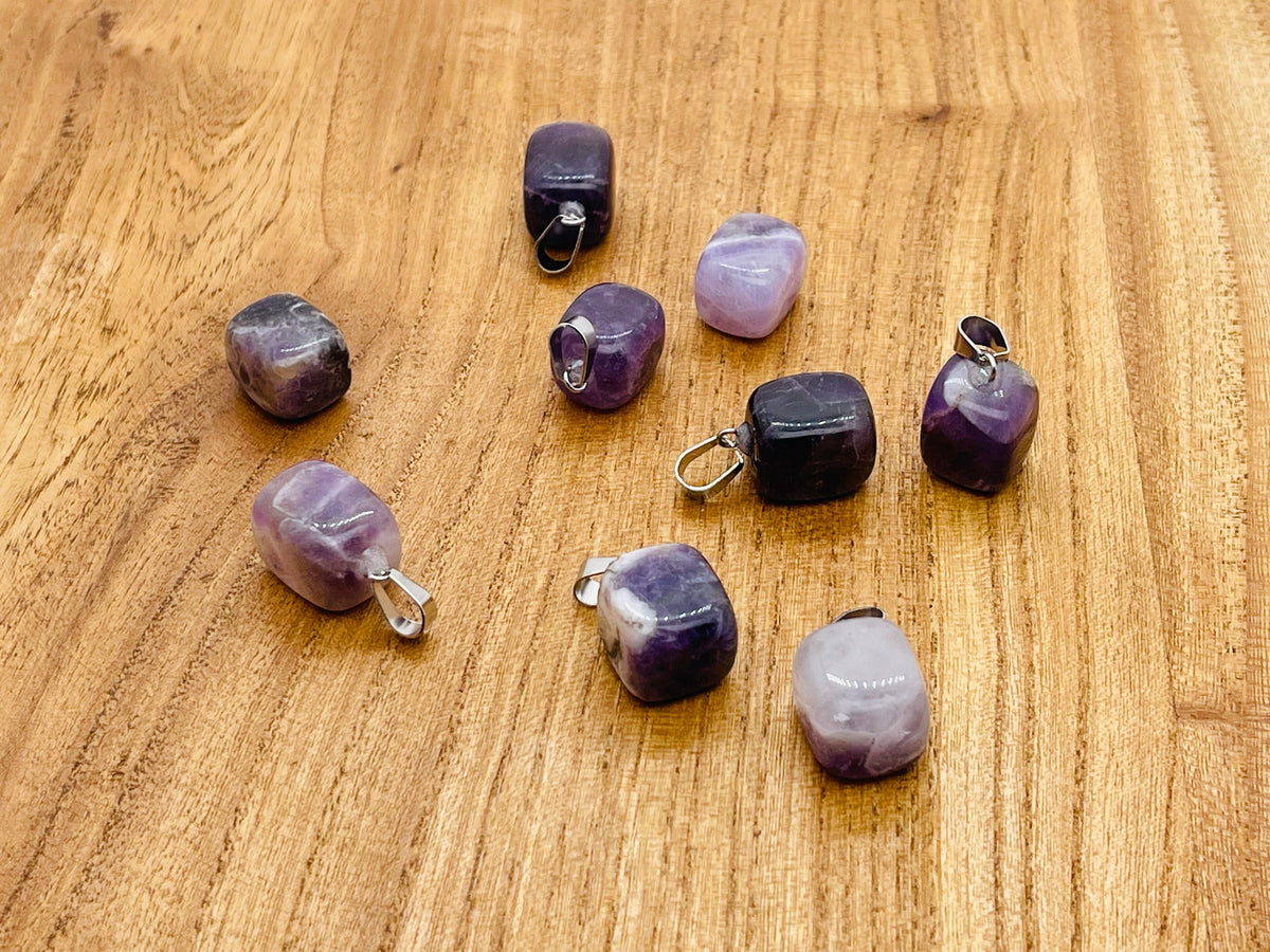Amethyst tumbled gemstone pendant from GemstoneGO featuring a smooth purple stone with silver bail on a white background.
