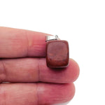 Red Jasper tumbled crystal pendant from GemstoneGO, showcasing a smooth, polished red stone with natural patterns and a silver bail.