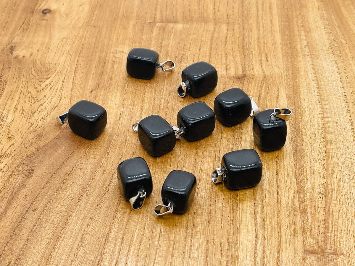 Obsidian tumbled gemstone pendant with natural black stone and smooth polished surface, pendant displayed on a white background.