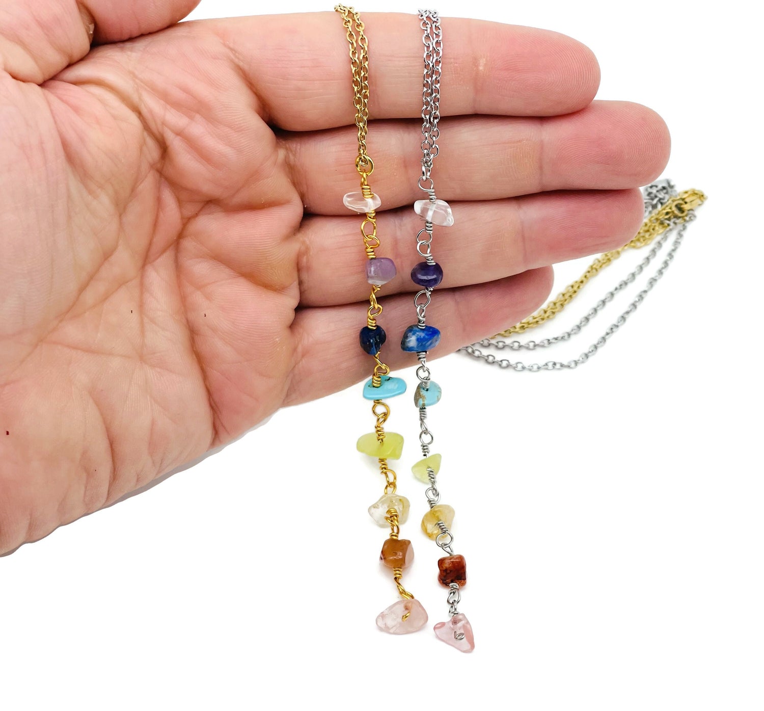 Silver and gold 7 chakra crystal necklace featuring colorful gemstones on a delicate chain, designed for spiritual balance and style.