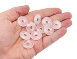 Pink rose quartz crystal donut from GemstoneGO, 20mm Pi stone with smooth polished surface and natural pink hue.