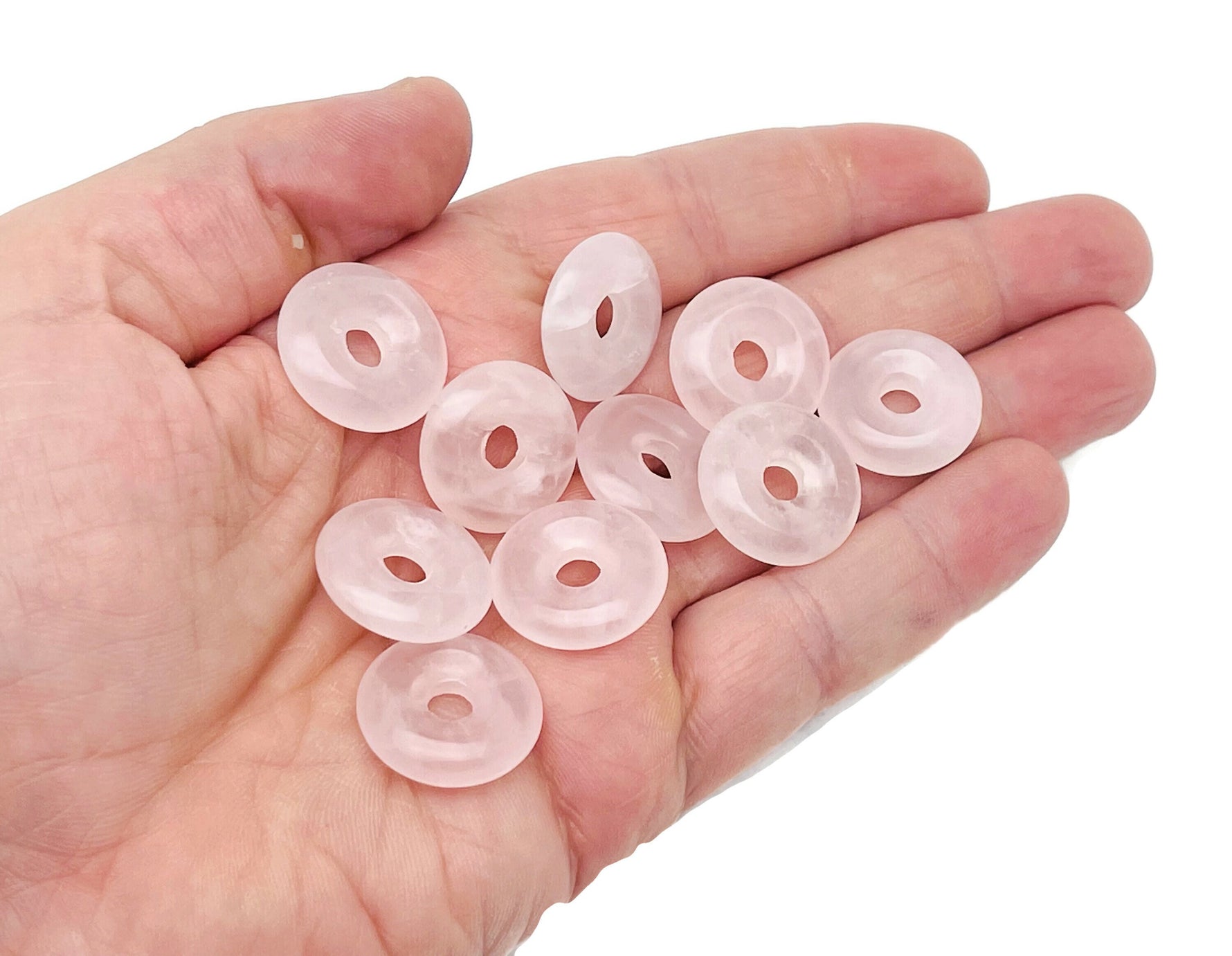 Pink rose quartz crystal donut from GemstoneGO, 20mm Pi stone with smooth polished surface and natural pink hue.