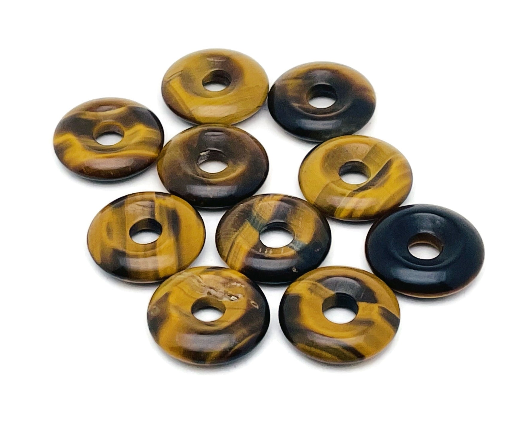 Polished 20mm Tiger Eye crystal donut pendant from GemstoneGO, showcasing its golden-brown chatoyancy and smooth, rounded shape.