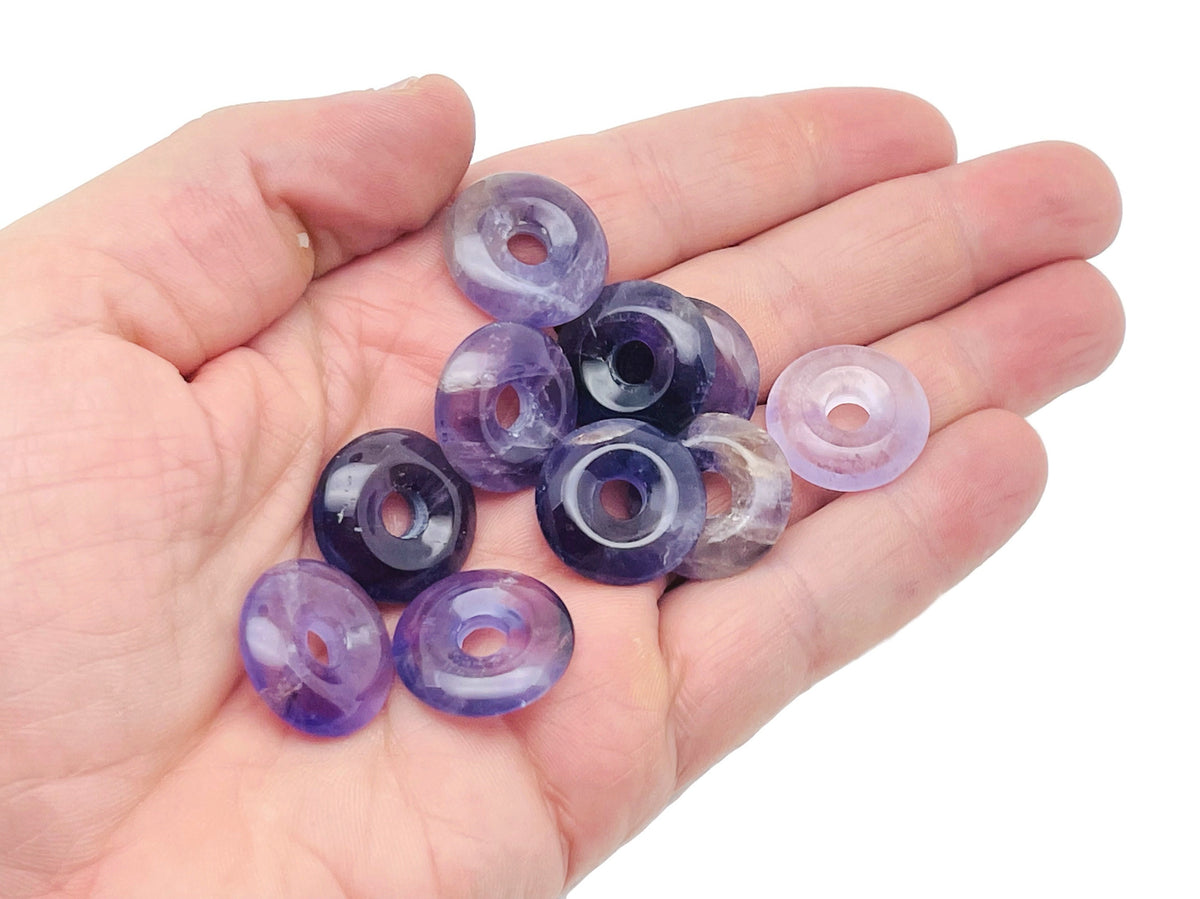 Amethyst crystal donut pendant from GemstoneGO, 20mm Pi stone with purple hues and polished smooth surface.