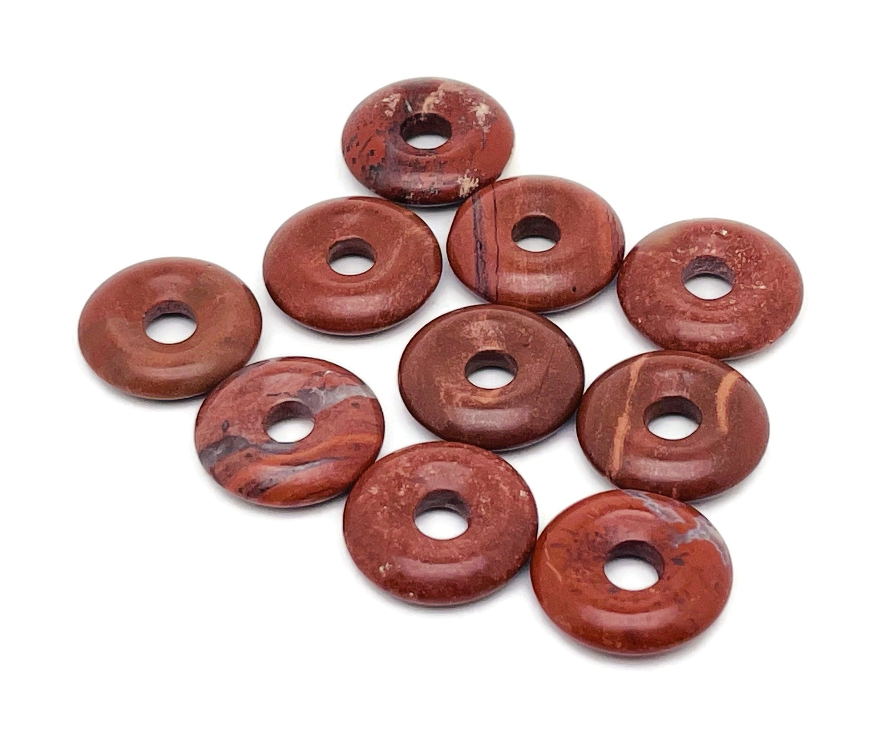 Red Jasper crystal donut pendant from GemstoneGO, 20mm Pi stone with a polished, smooth surface and vibrant red color.