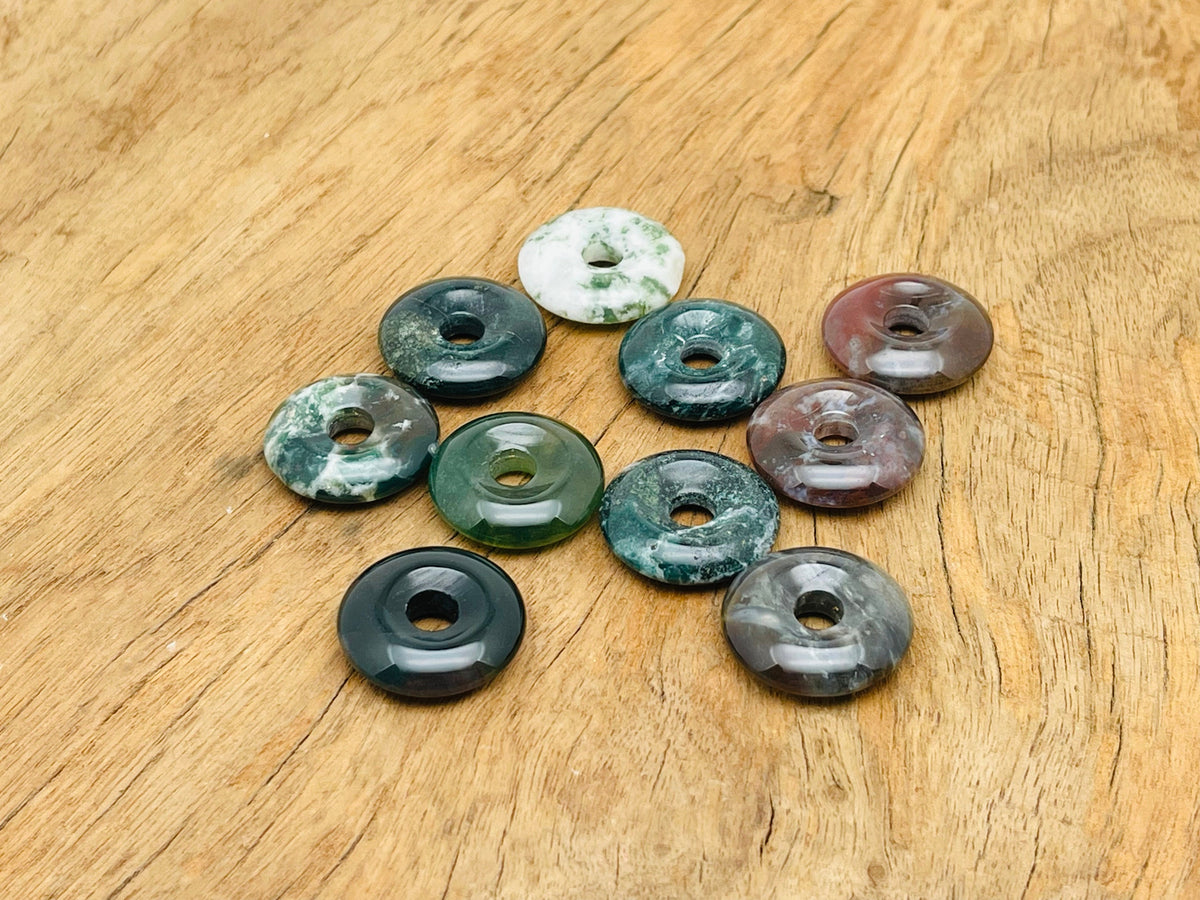 Moss agate crystal donut pendant from GemstoneGO, 20mm Pi stone with intricate green and brown moss patterns.