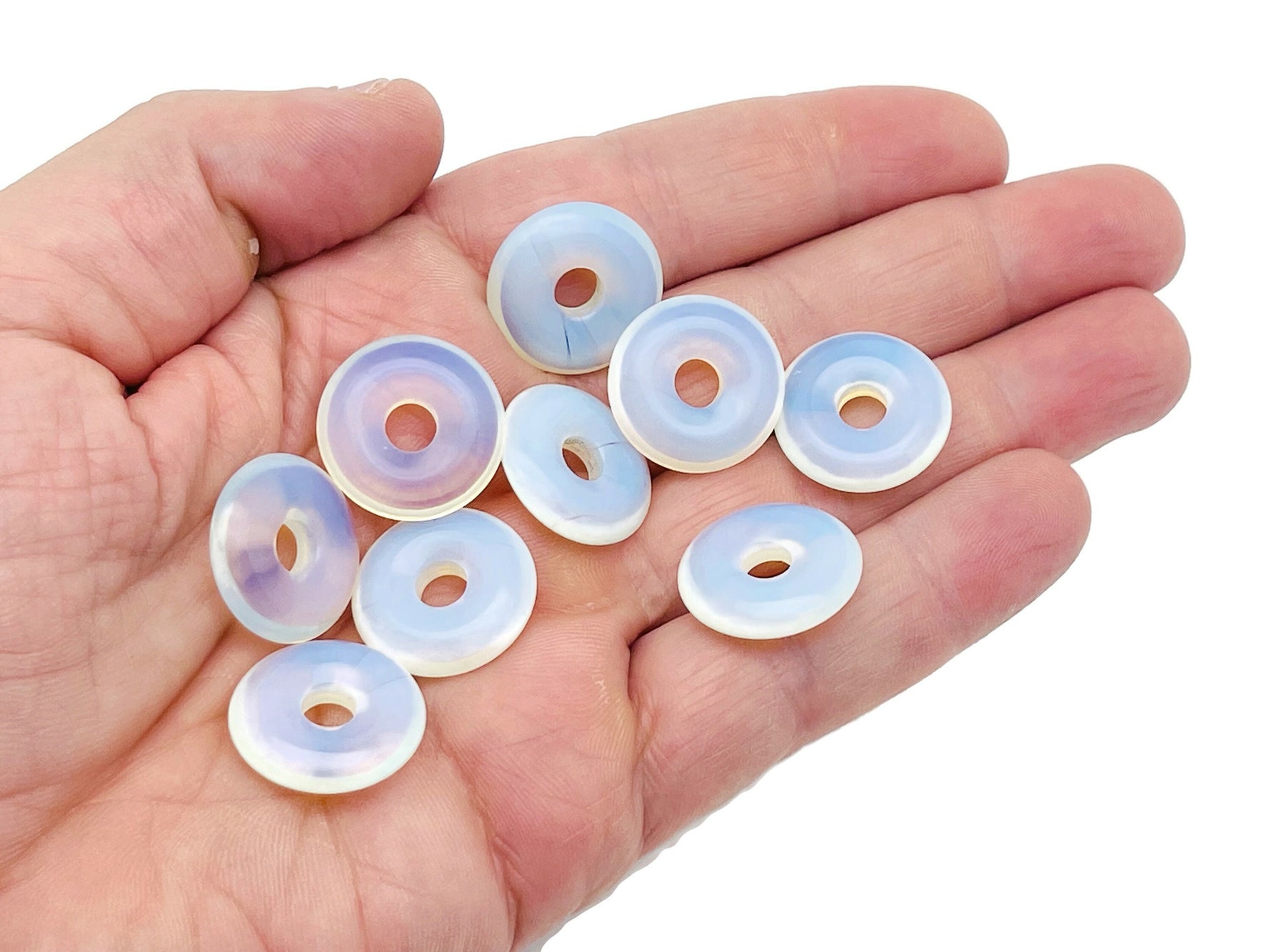 Opalite crystal donut pendant, 20mm Pi stone from GemstoneGO, showing its smooth, iridescent surface and rounded shape.