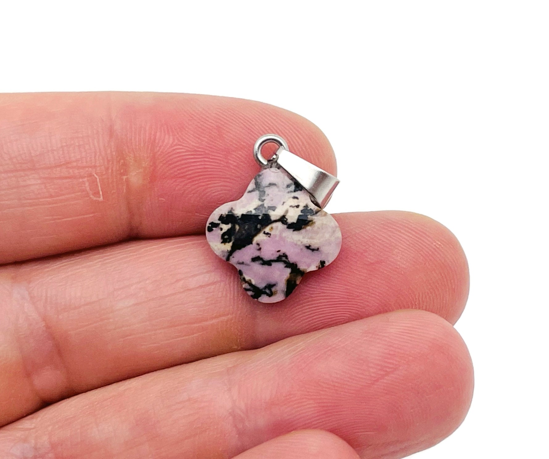 Rhodonite four-leaf clover crystal pendant from GemstoneGO, showcasing a pink gemstone pendant with a silver bail for jewelry making.