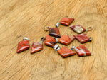 Red Jasper triangle gemstone pendant from GemstoneGO featuring a geometric design and polished finish.