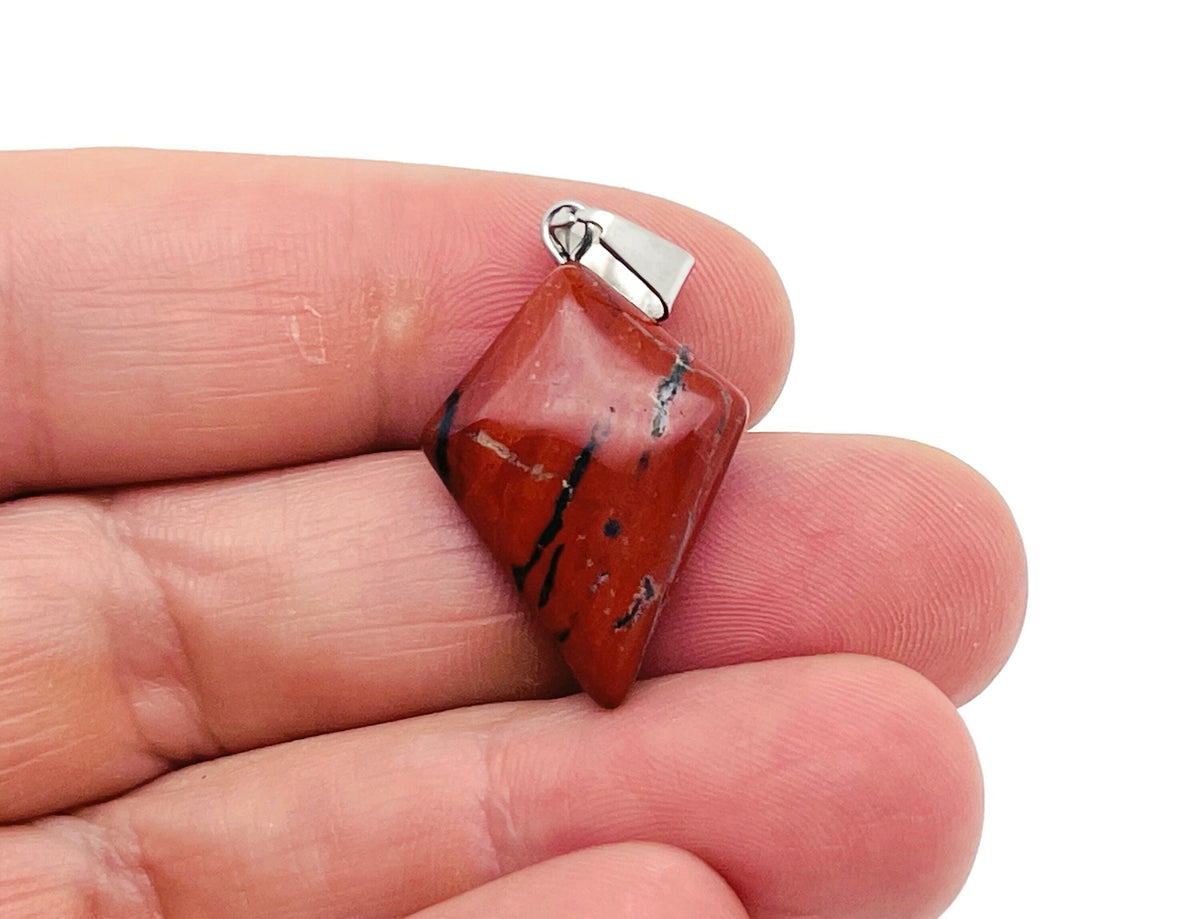 Red Jasper triangle gemstone pendant from GemstoneGO featuring a geometric design on a silver chain.