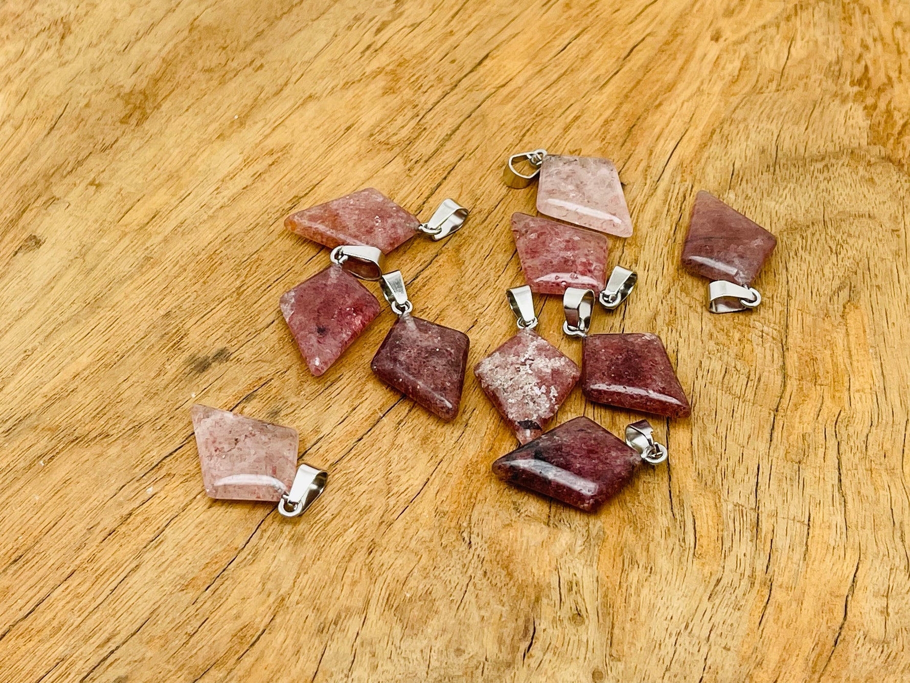Strawberry Quartz triangle gemstone pendant from GemstoneGO, showcasing a geometric red-pink gemstone on a silver chain.
