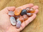 Crimson Agate tumbled stone from GemstoneGO showing deep red and orange hues with smooth, polished surface.
