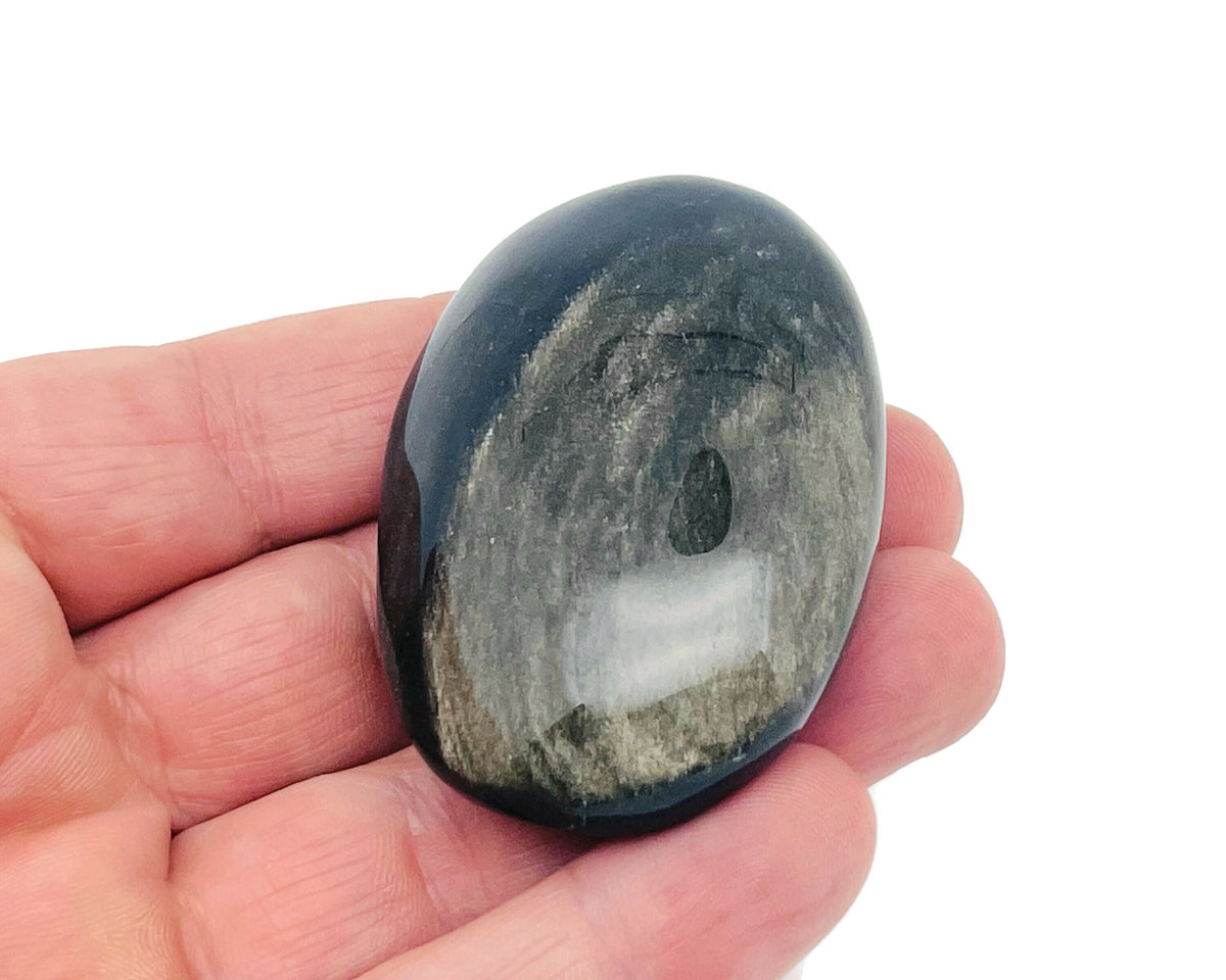 Golden Sheen Obsidian palm gemstone spa stone from GemstoneGO, showing its smooth, polished surface with golden shimmer details.
