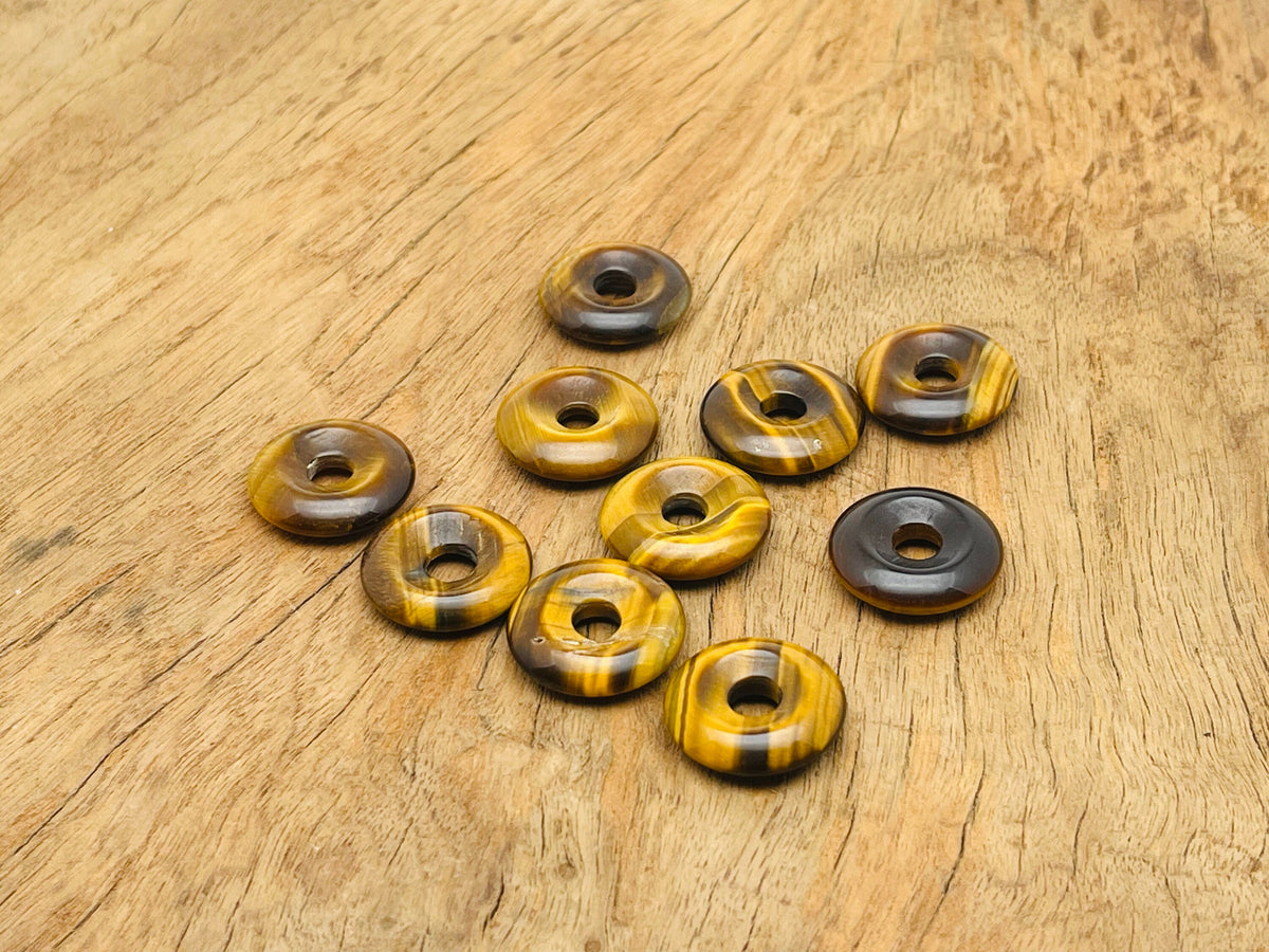Tiger Eye crystal donut pendant, 20mm Pi stone from GemstoneGO, showcasing the smooth, polished gemstone with golden-brown bands.