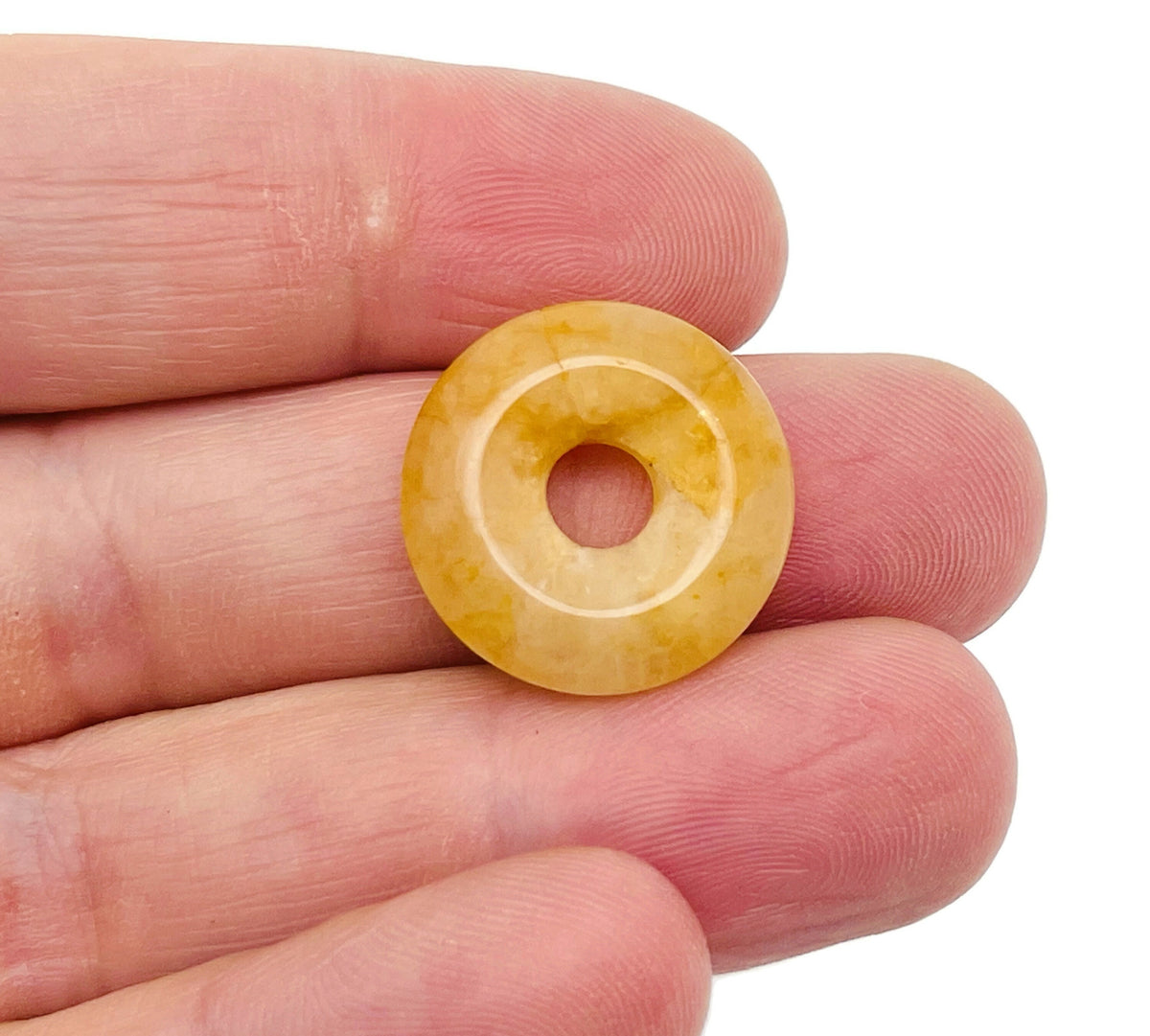 Yellow jade crystal donut pendant, 20mm Pi stone from GemstoneGO, showcasing a polished yellow jade gemstone with a hole in the center.