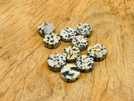 Round Dalmatian Jasper flat gemstone slab from GemstoneGO showing black and cream spotted pattern on polished surface.