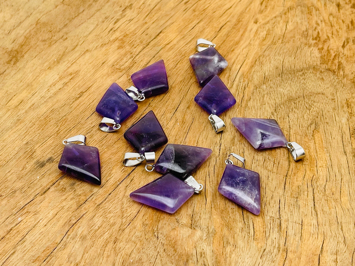 Amethyst triangle gemstone pendant from GemstoneGO showcasing a geometric purple stone on a silver chain.