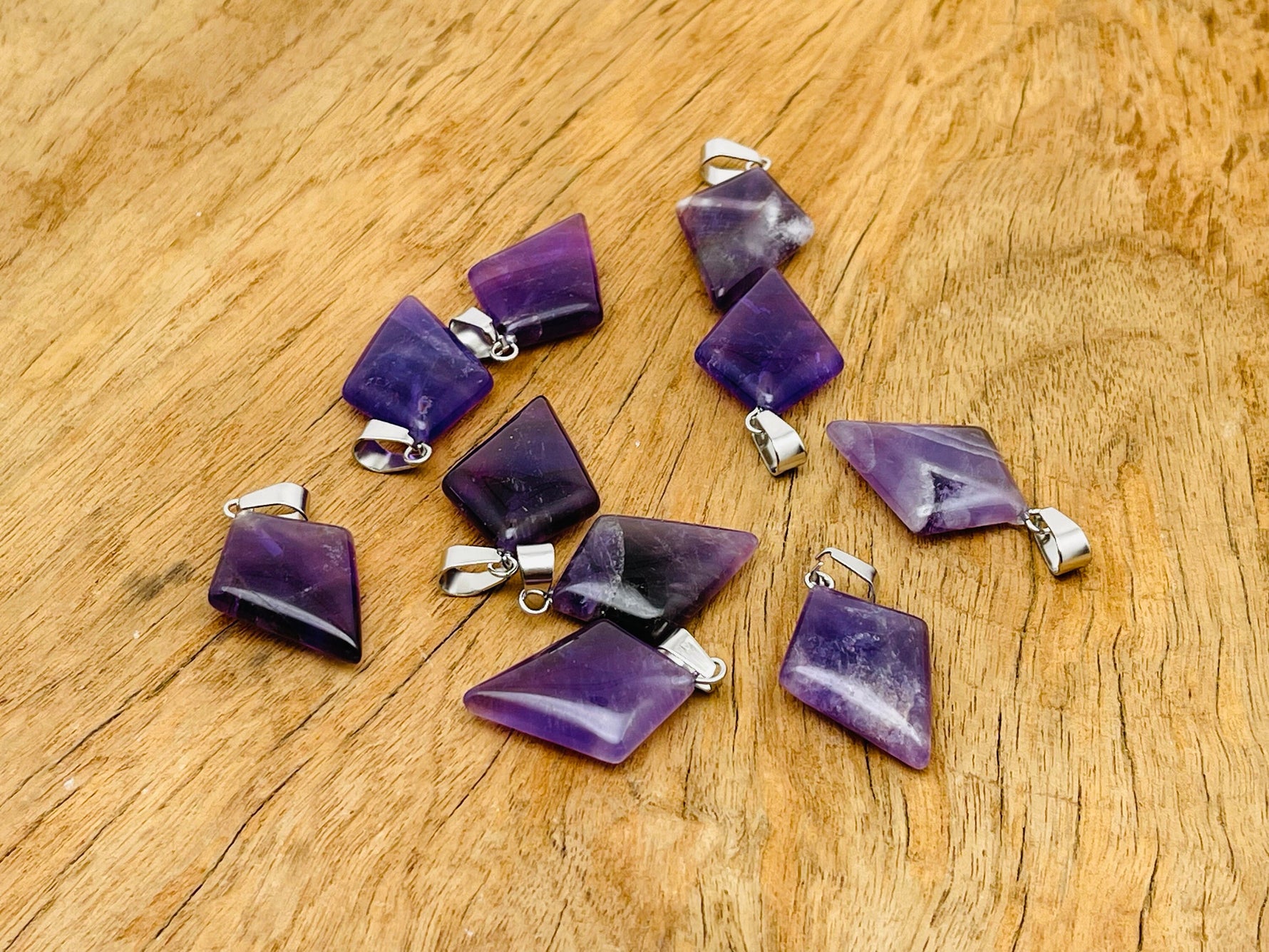 Amethyst triangle gemstone pendant from GemstoneGO showcasing a geometric purple stone on a silver chain.