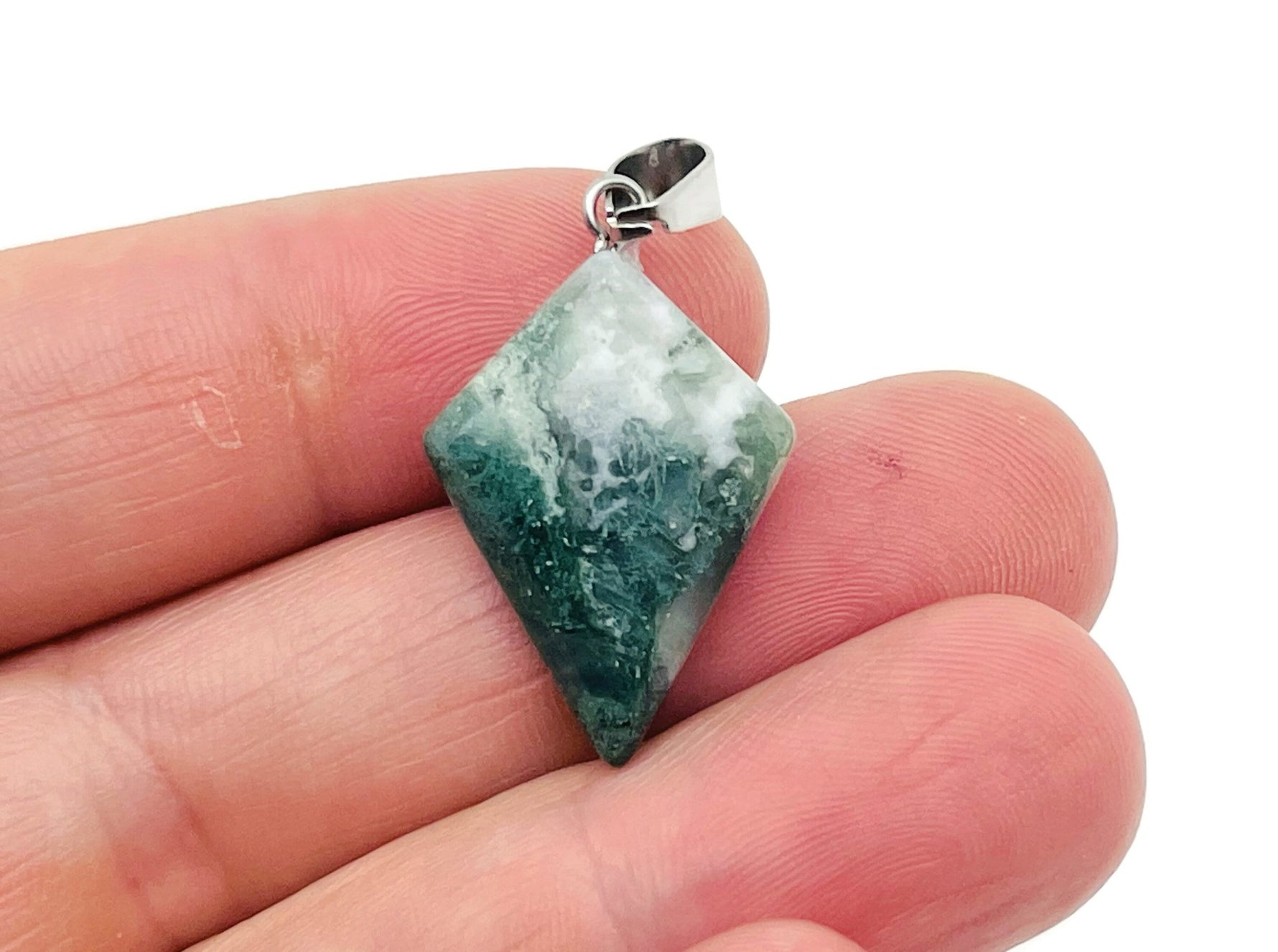 Moss agate triangle gemstone pendant with geometric design, showcasing natural green and brown mineral patterns.