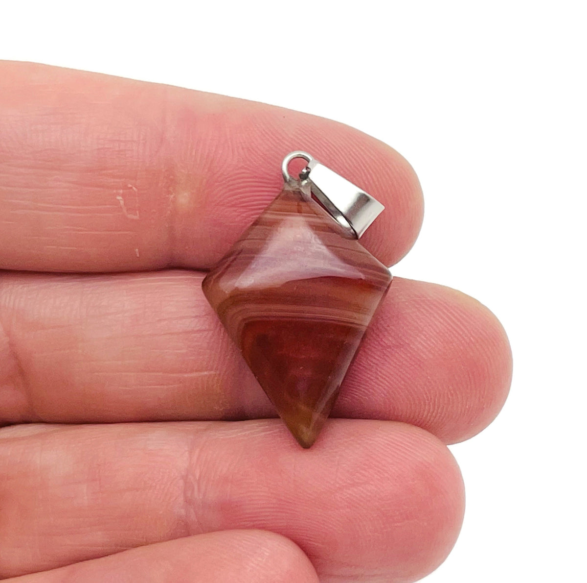 Carnelian triangle gemstone pendant from GemstoneGO featuring a geometric design and vibrant orange-red color.