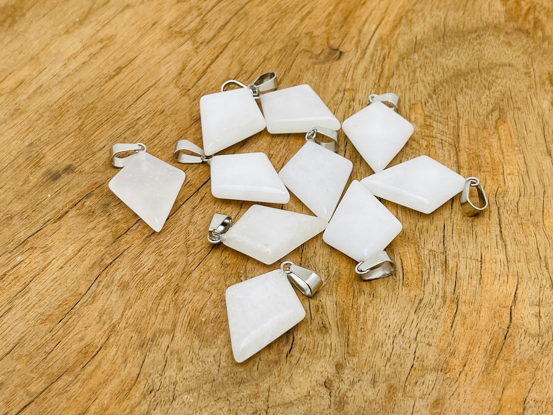 White jade triangle gemstone pendant with geometric design, crafted by GemstoneGO, featuring a smooth, polished finish.