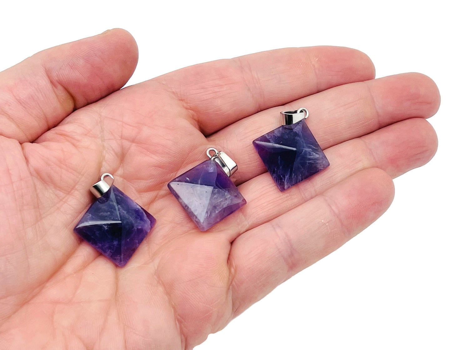 Natural amethyst pyramid gemstone pendant from GemstoneGO, showcasing a purple, polished crystal pendant on a silver chain.