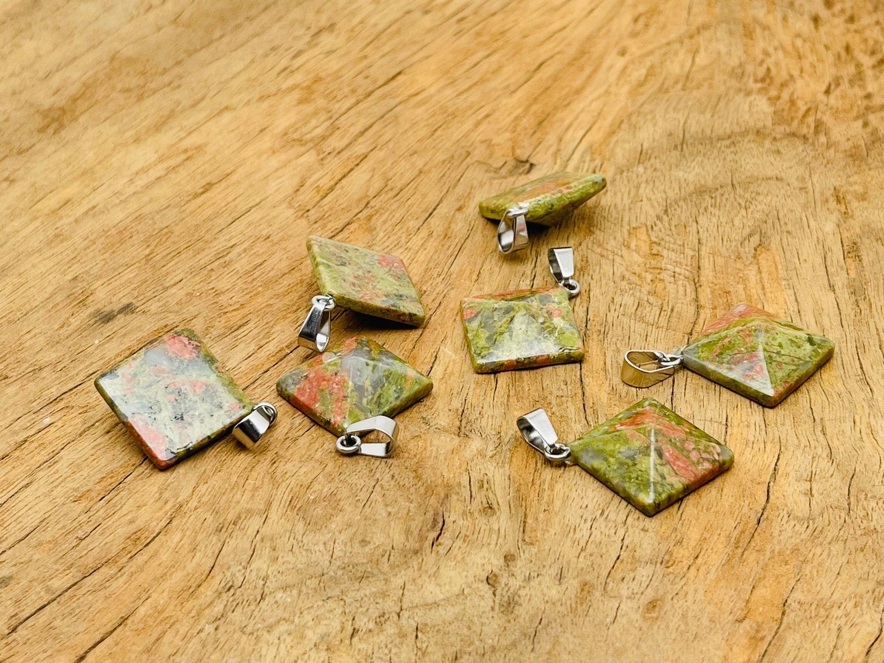 Unakite pyramid gemstone pendant from GemstoneGO, showcasing a natural green and pink stone with polished facets.