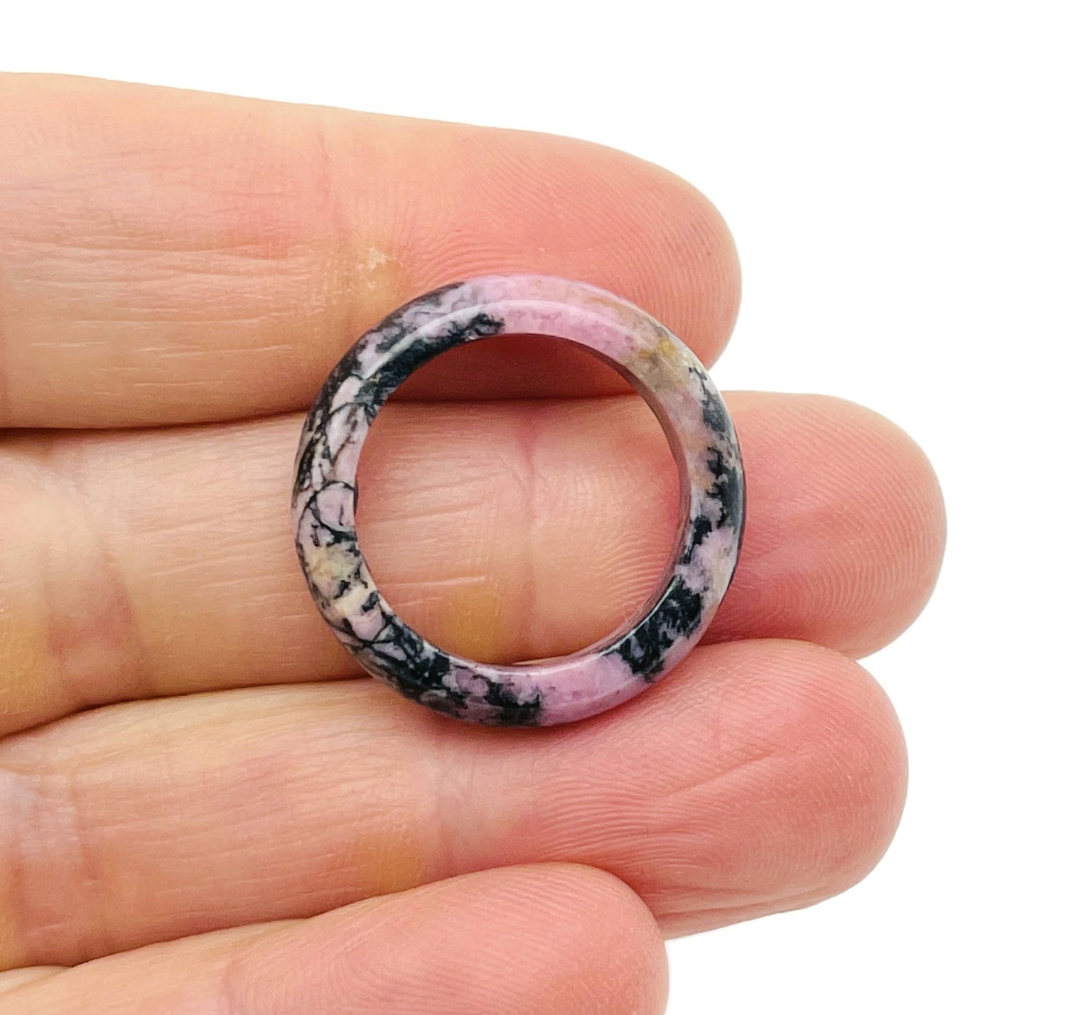 Rhodonite crystal ring by GemstoneGO featuring a polished pink stone set in a silver band, showcasing elegant jewelry design.