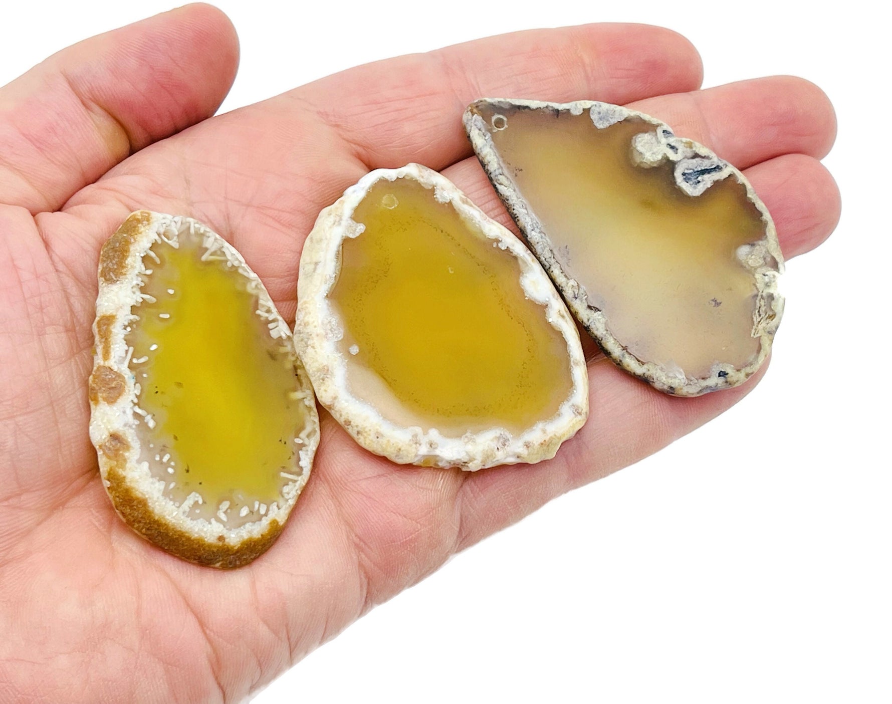 Yellow agate slice drilled pendant showing a vibrant yellow geode with natural patterns and a drilled hole for jewelry making.