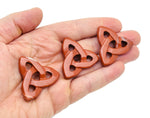 Red Jasper Celtic knot carved gemstone Trinity Crystal from GemstoneGO, showcasing intricate knot design and vibrant red color.