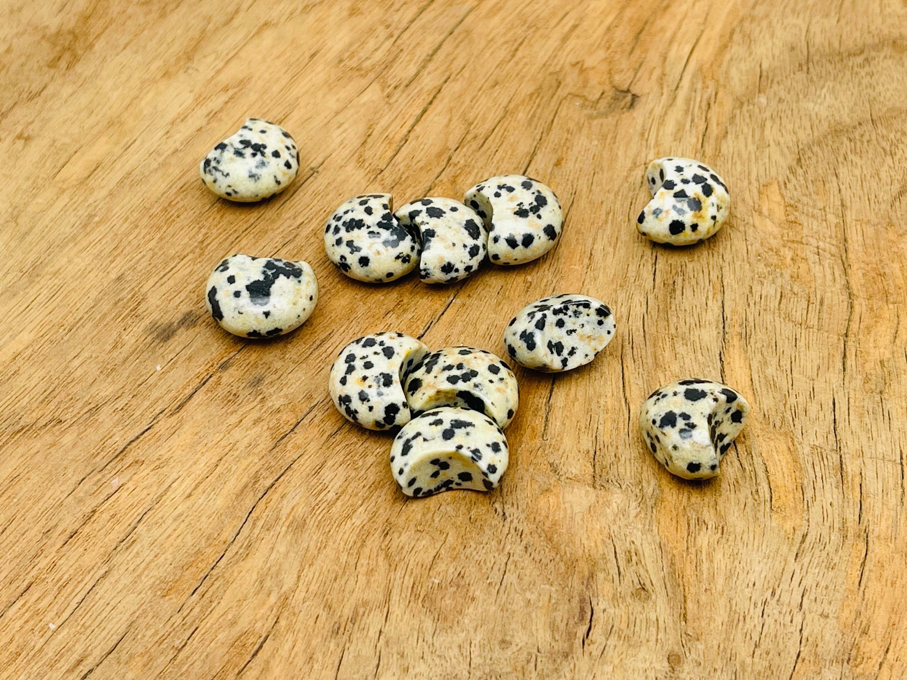 Dalmatian Jasper gemstone moon puffy charm, 15x9mm, with distinctive black spots on cream-colored stone, from GemstoneGO.