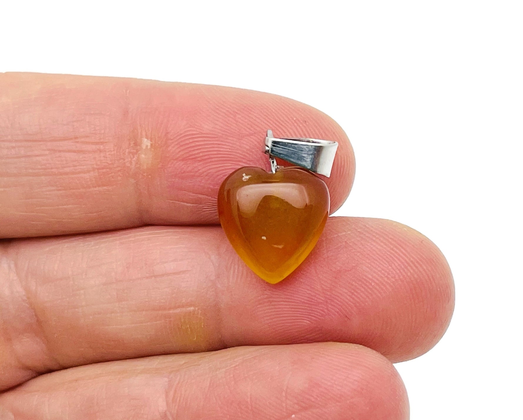 Mini crystal pendant featuring a carved carnelian heart, crafted by GemstoneGO, showcasing vibrant orange gemstone jewelry.