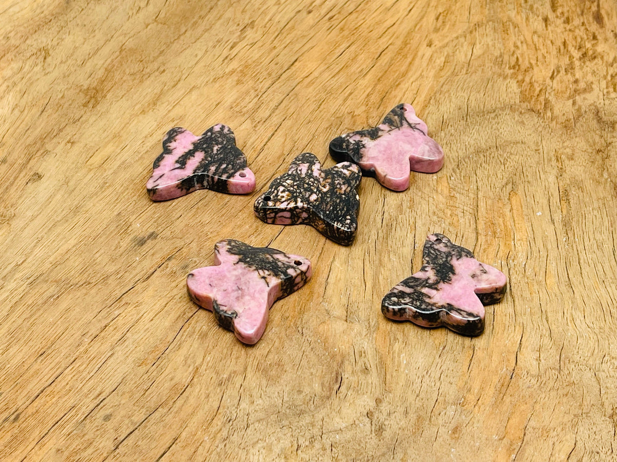 Rhodonite butterfly gemstone pendant with hole crystal jewelry featuring a vibrant pink and black patterned stone.