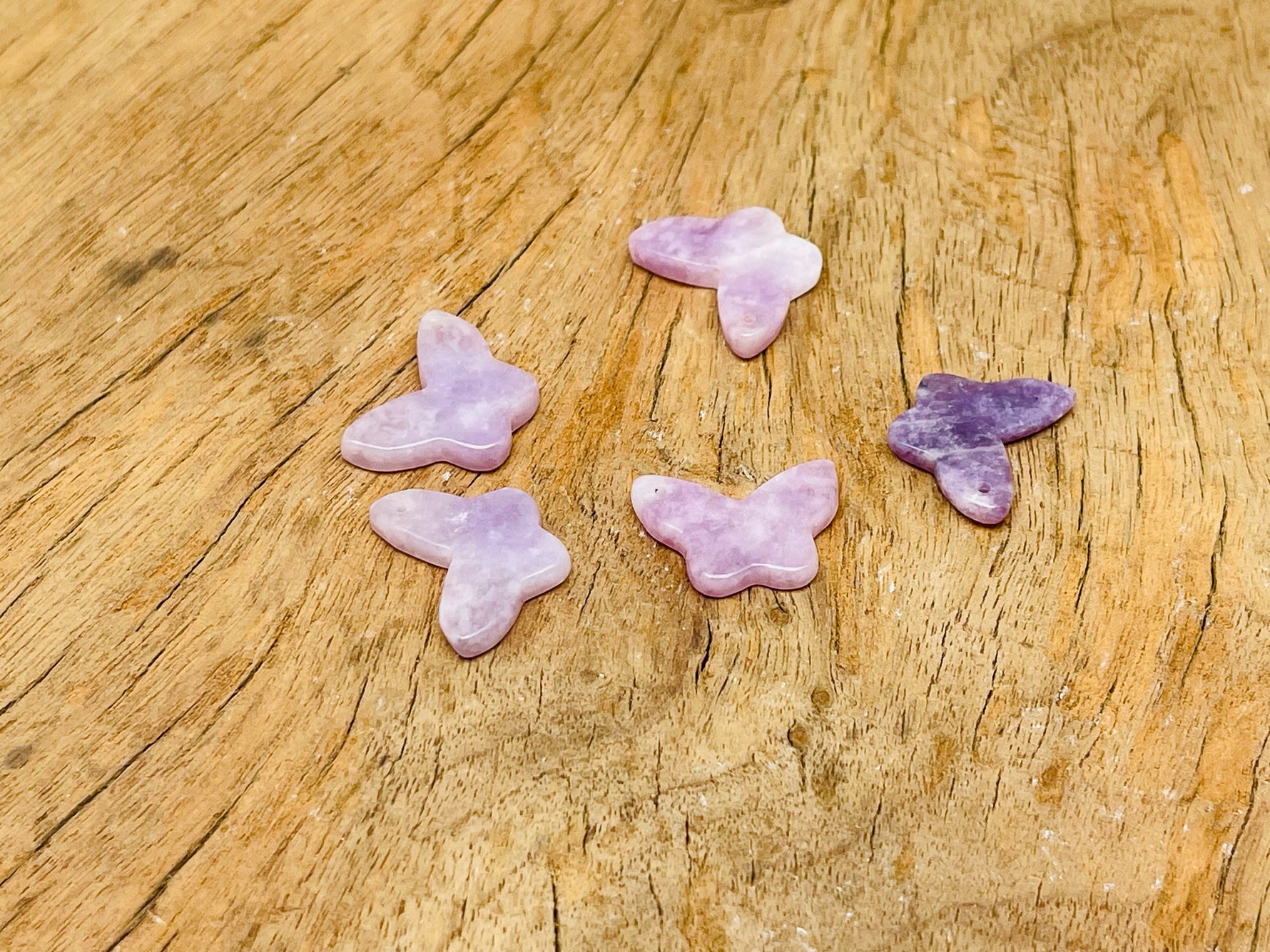 Lepidolite mini butterfly gemstone pendant from GemstoneGO, featuring a hole drilled crystal jewelry piece on a white background.