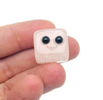Handmade rose quartz carving of a skull gemstone by GemstoneGO, displayed against a neutral background.