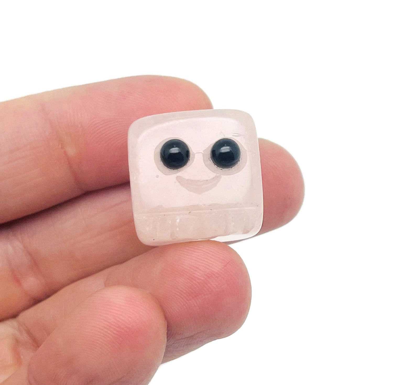 Handmade rose quartz carving of a skull gemstone by GemstoneGO, displayed against a neutral background.