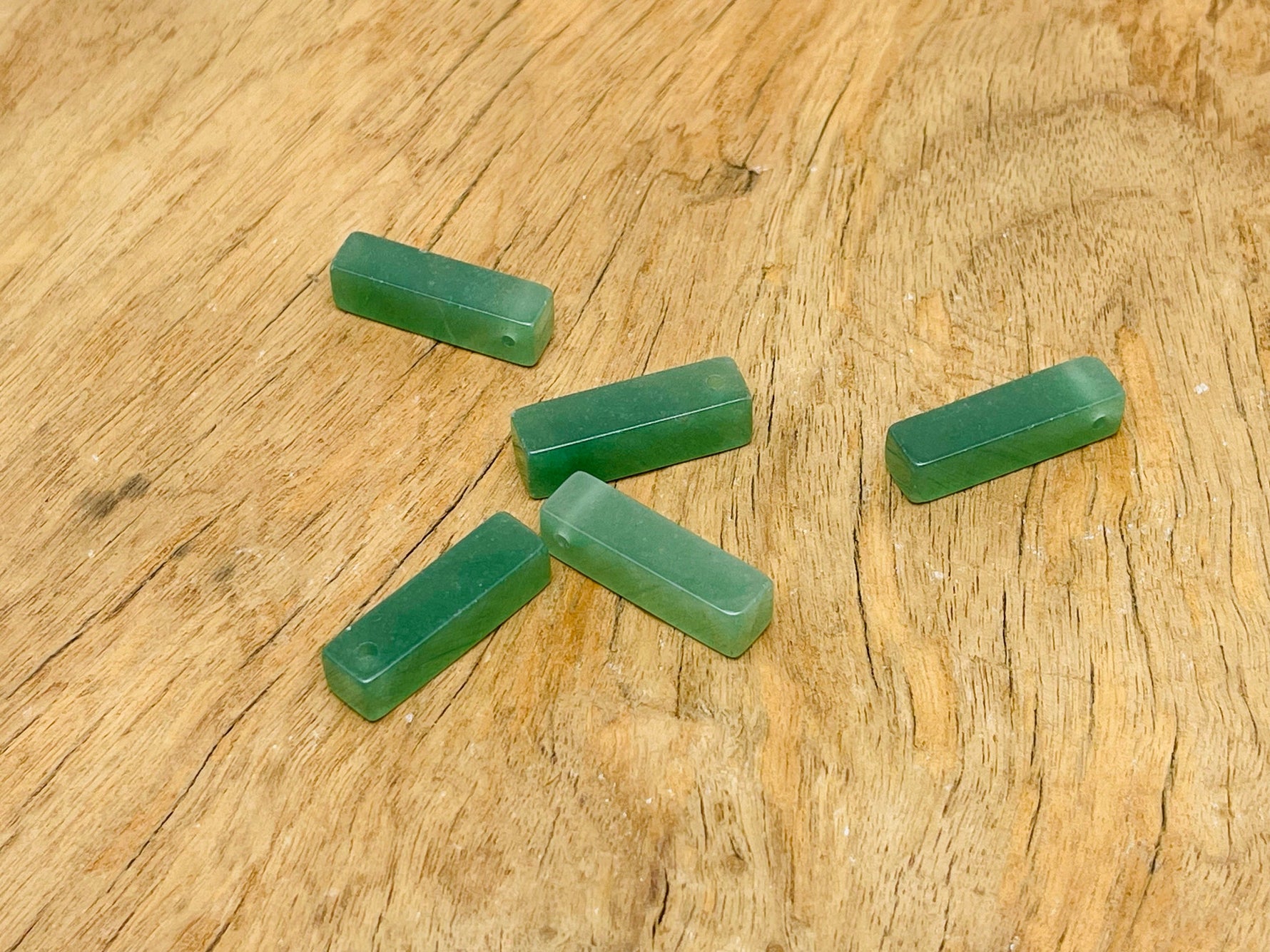 A polished aventurine crystal pendant with a drilled hole, suitable for jewelry making, displayed on a neutral background.