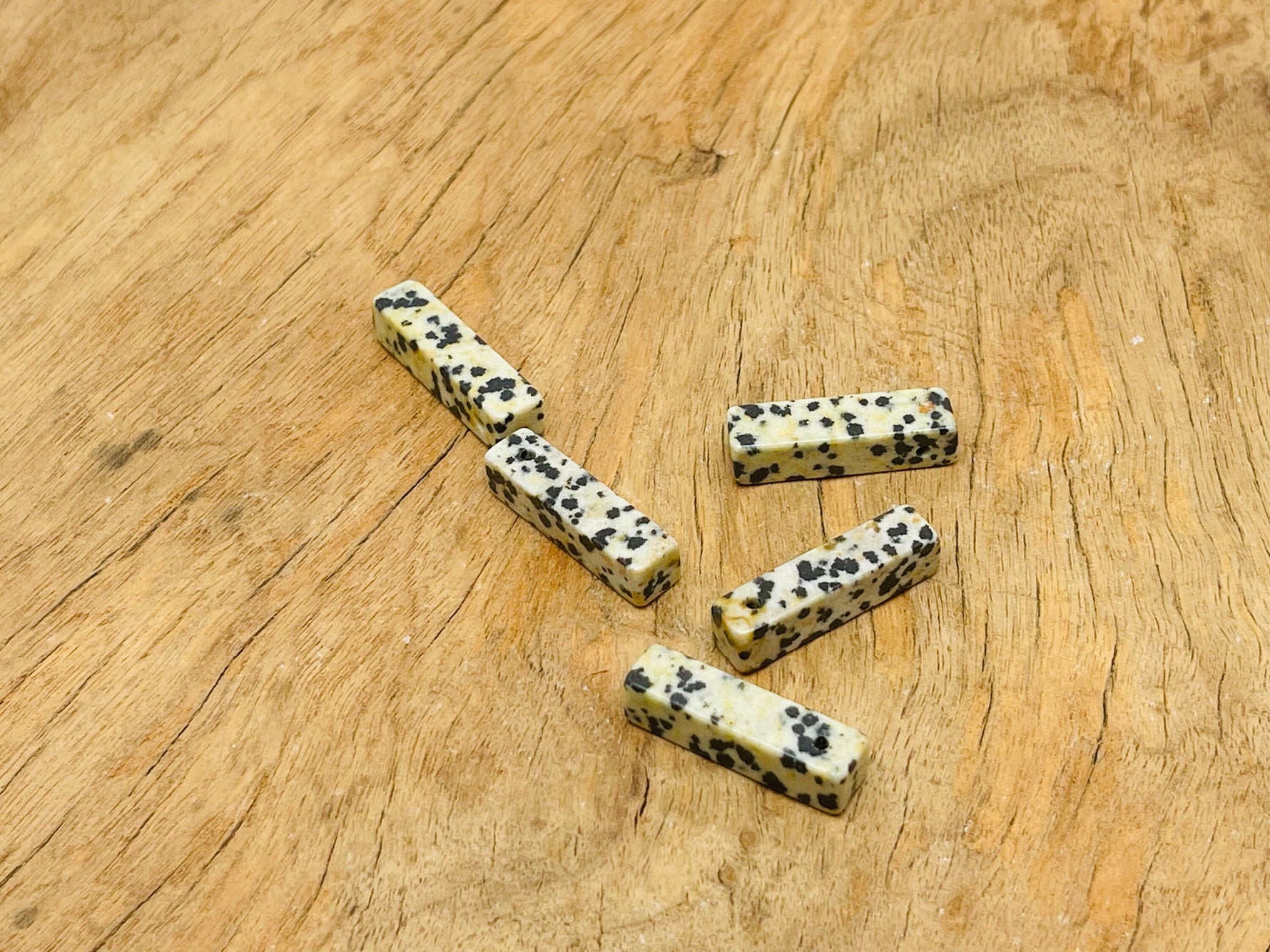 Dalmatian Jasper crystal pendant from GemstoneGO, drilled for jewelry making, showcasing black and cream spotted stone.