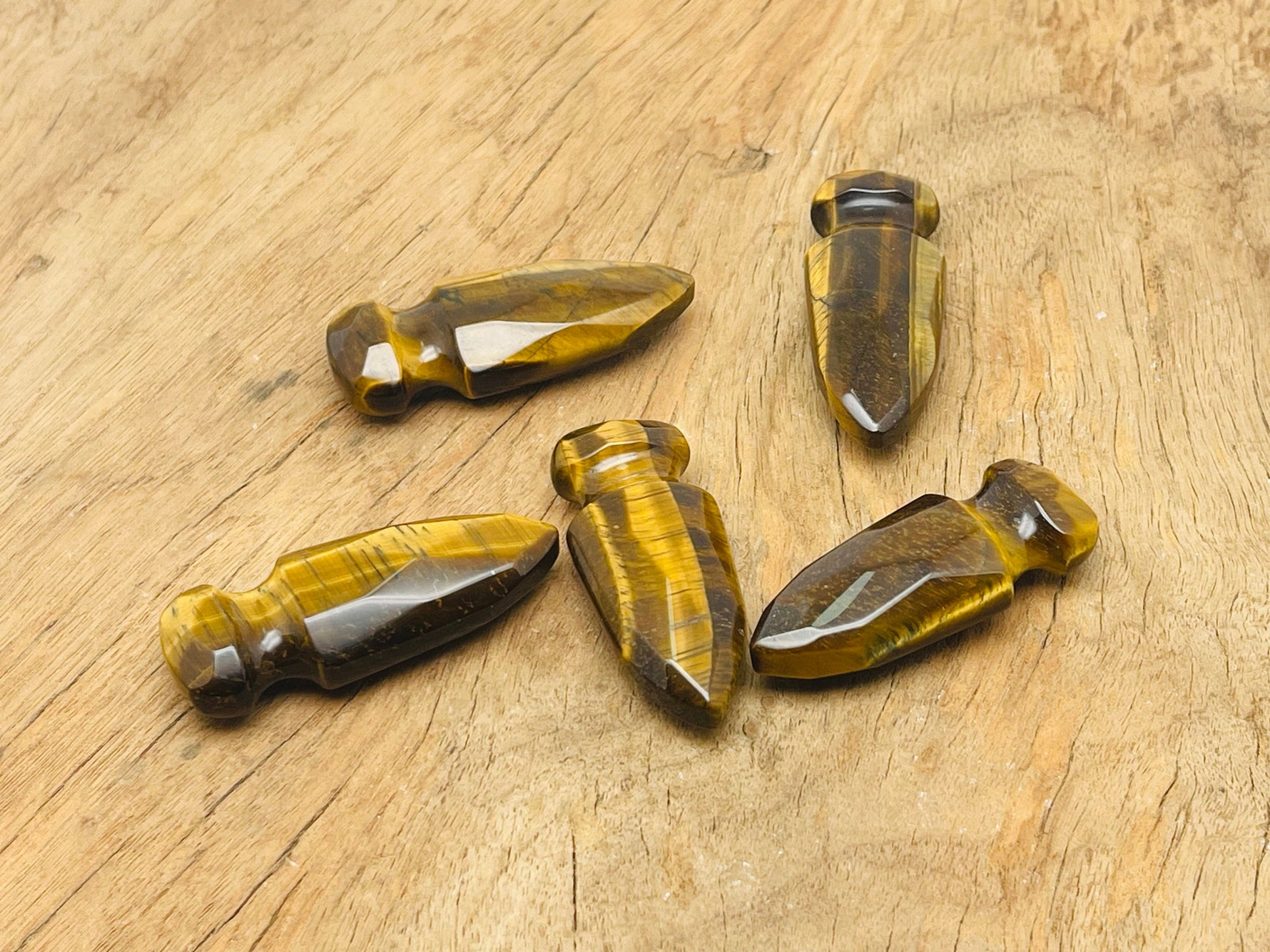 Carved Tiger Eye gemstone sword dagger pendant, 50mm, with detailed craftsmanship and natural gemstone coloration.