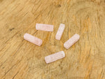 Rose quartz crystal pendant from GemstoneGO, drilled gemstone for jewelry making, showcasing a smooth pink stone on a clear background.