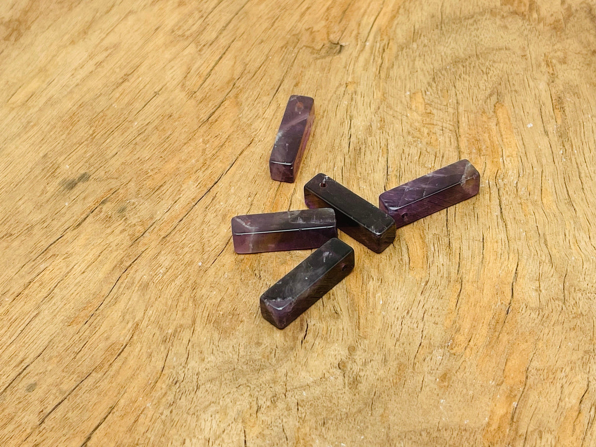 Amethyst crystal pendant from GemstoneGO, drilled for jewelry making, showcasing a purple gemstone with natural facets and polished surface.