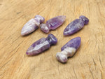 Carved amethyst gemstone sword dagger measuring 50mm, featuring intricate details and natural purple hues, from GemstoneGO.