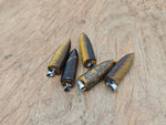 Polished tiger eye bullet gemstone pendant with carved design, featuring natural golden-brown hues and smooth, rounded shape.
